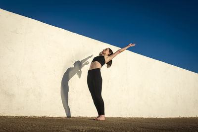 Fit sporty woman doing stretching exercise outside.