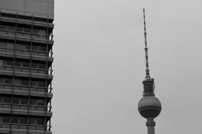 Low angle view of communications tower in city