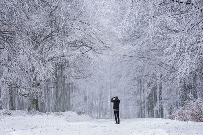 Rear view of person standing on snow covered land