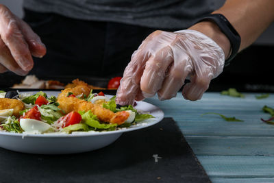 Close-up of person preparing food in plate