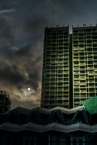 Low angle view of skyscraper against cloudy sky