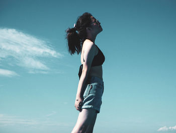 Low angle view of woman standing against sky