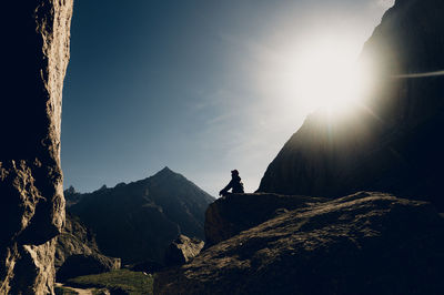 Rear view of man standing on mountain against sky