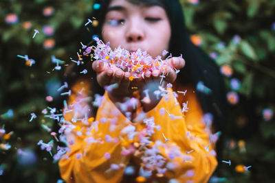 Close-up of woman with red flower