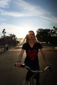 Rear view of woman standing against sky during sunset