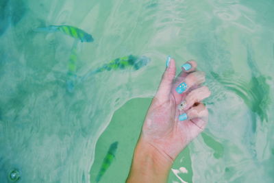 Close-up of person hand in sea