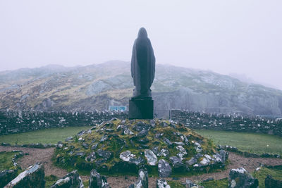 Statue on mountain against clear sky