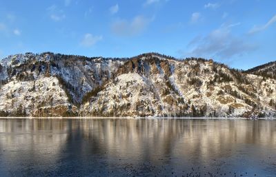 Scenic view of lake by mountains against sky