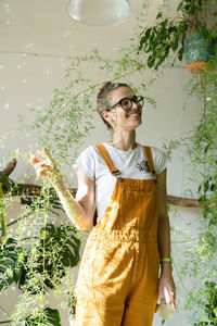 Smiling gardener standing by plants