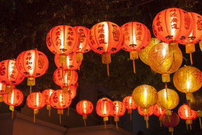 Low angle view of illuminated lanterns hanging at night