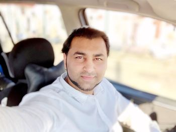 Portrait of young man sitting in car