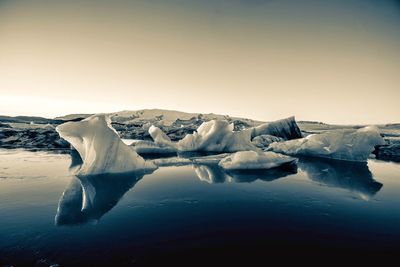 Frozen lake against sky during winter