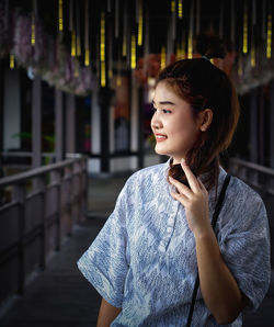 Smiling beautiful woman looking away while standing in temple