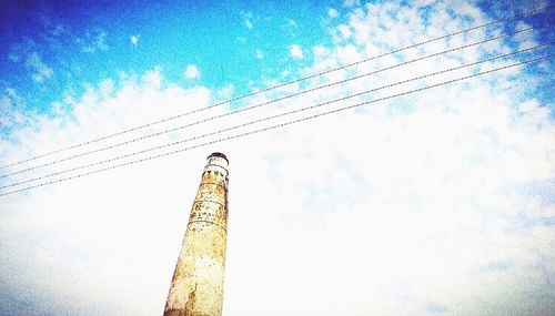 Low angle view of electricity pylon against blue sky