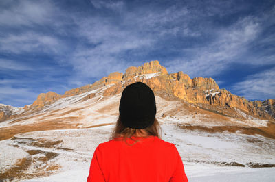 Rear view of woman looking at mountain against sky