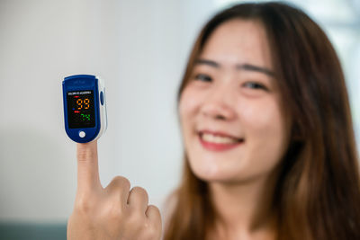 Portrait of young woman holding mobile phone