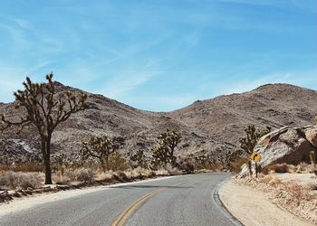 Road by mountain against sky