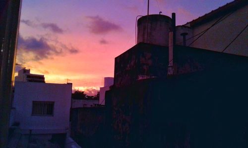 Silhouette of water tower against sky at sunset