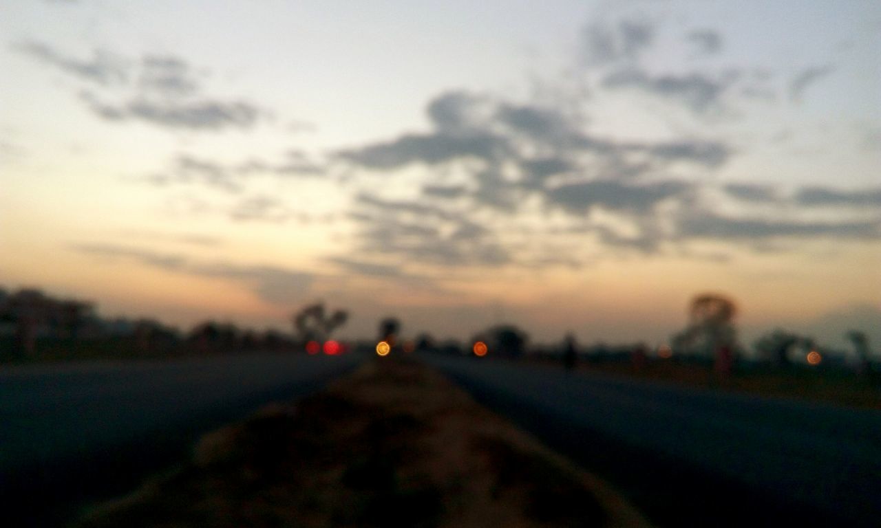 ROAD PASSING THROUGH LANDSCAPE AT SUNSET