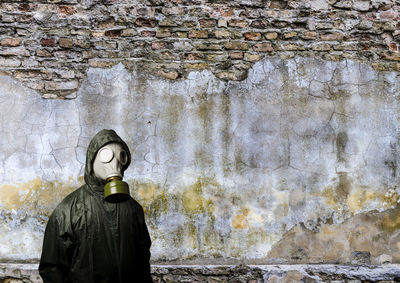 Rear view of man standing against brick wall