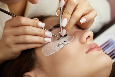 Midsection of woman applying nail polish