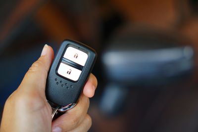 Close-up of person holding car key