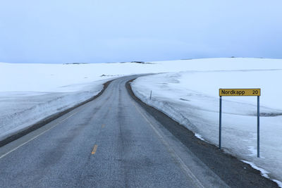 View of road sign against sky during winter