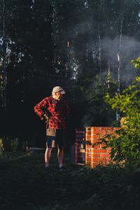 Woman standing by tree in forest