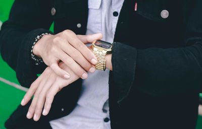 Midsection of businesswoman checking time while sitting in office