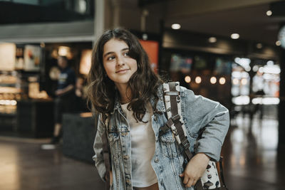 Contemplative girl wearing denim jacket while standing at station