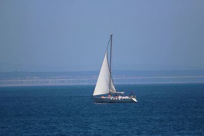 Sailboat sailing on sea against sky