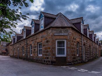 Buildings by street against sky