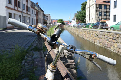 Bicycle parked by river in city