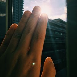 Cropped image of hand touching glass window