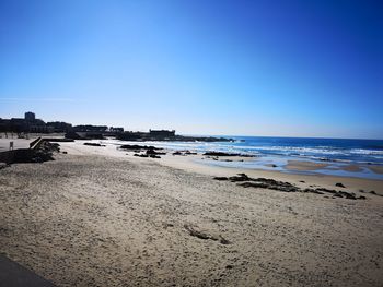 Scenic view of beach against clear blue sky