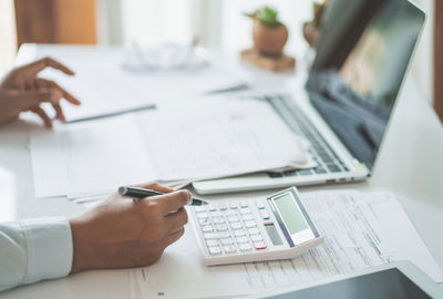 Midsection of man using laptop on table