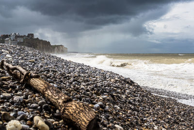 Pebbles on beach against sky