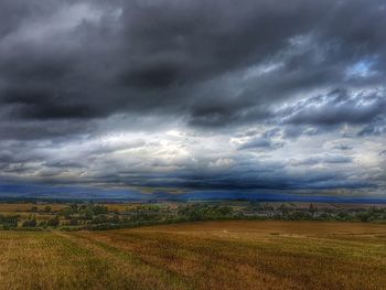 Scenic view of field against cloudy sky