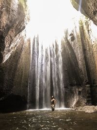 Man against waterfall in forest