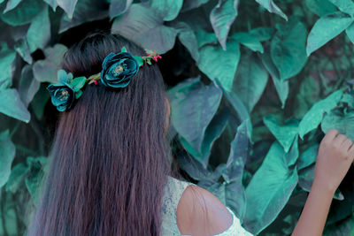 Rear view of woman with leaves