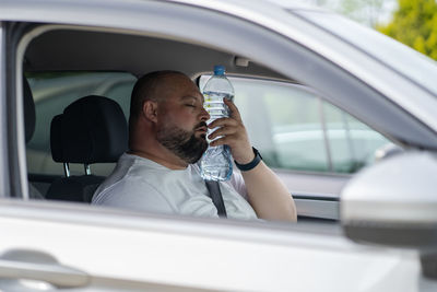 Side view of woman using mobile phone while sitting in car