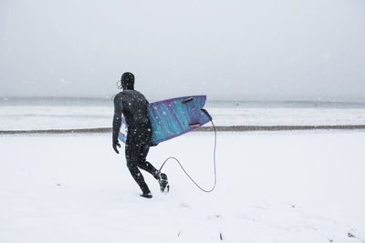 Man going surfing during winter snow