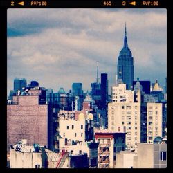 View of cityscape against cloudy sky