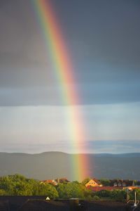 Rainbow over landscape against sky