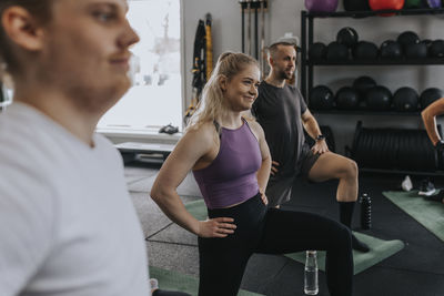 Smiling woman standing in gym during fitness class