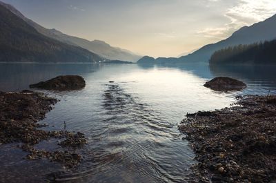 Scenic view of lake by mountains against sky