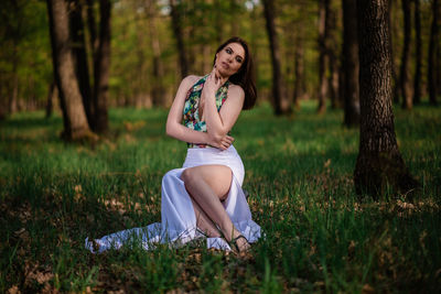 Portrait of young woman sitting on field