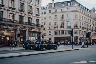 Vehicles on road by buildings in city