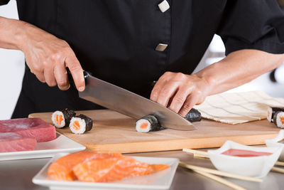 Midsection of chef preparing sushi in commercial kitchen