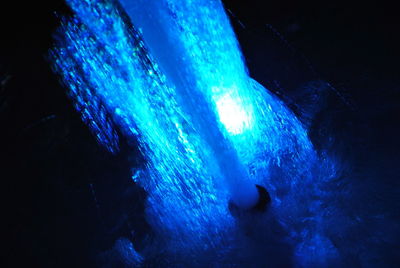 Aerial view of illuminated blue water at night